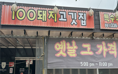 100돼지고깃집 간판과 옛날 그 가격 문구와, 영업시간은 오후 5시부터 11시까지 현수막이 있다.
