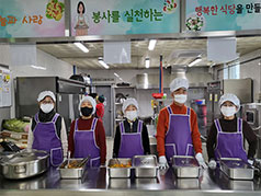 급식소 내부에서 위생모와 앞치마를 착용하고 배식 하고 있는 사람들 모습