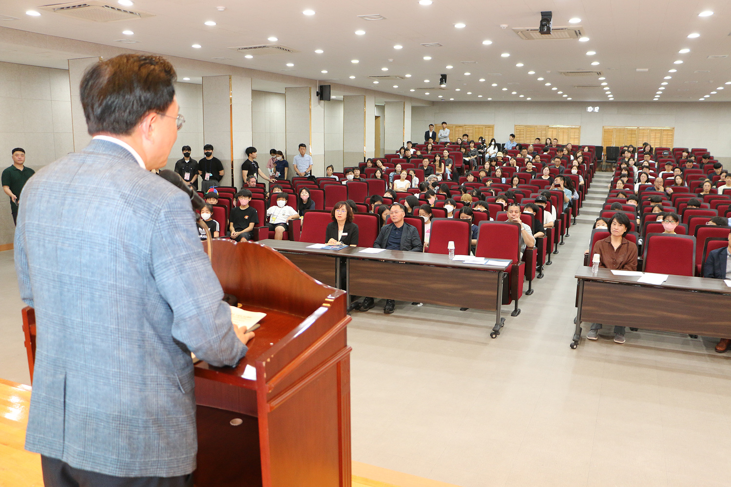 나주시 여름방학 영어캠프 수료식 나주시장의 축사 뒷모습과 참석 학생들의 앉아 있는 앞모습