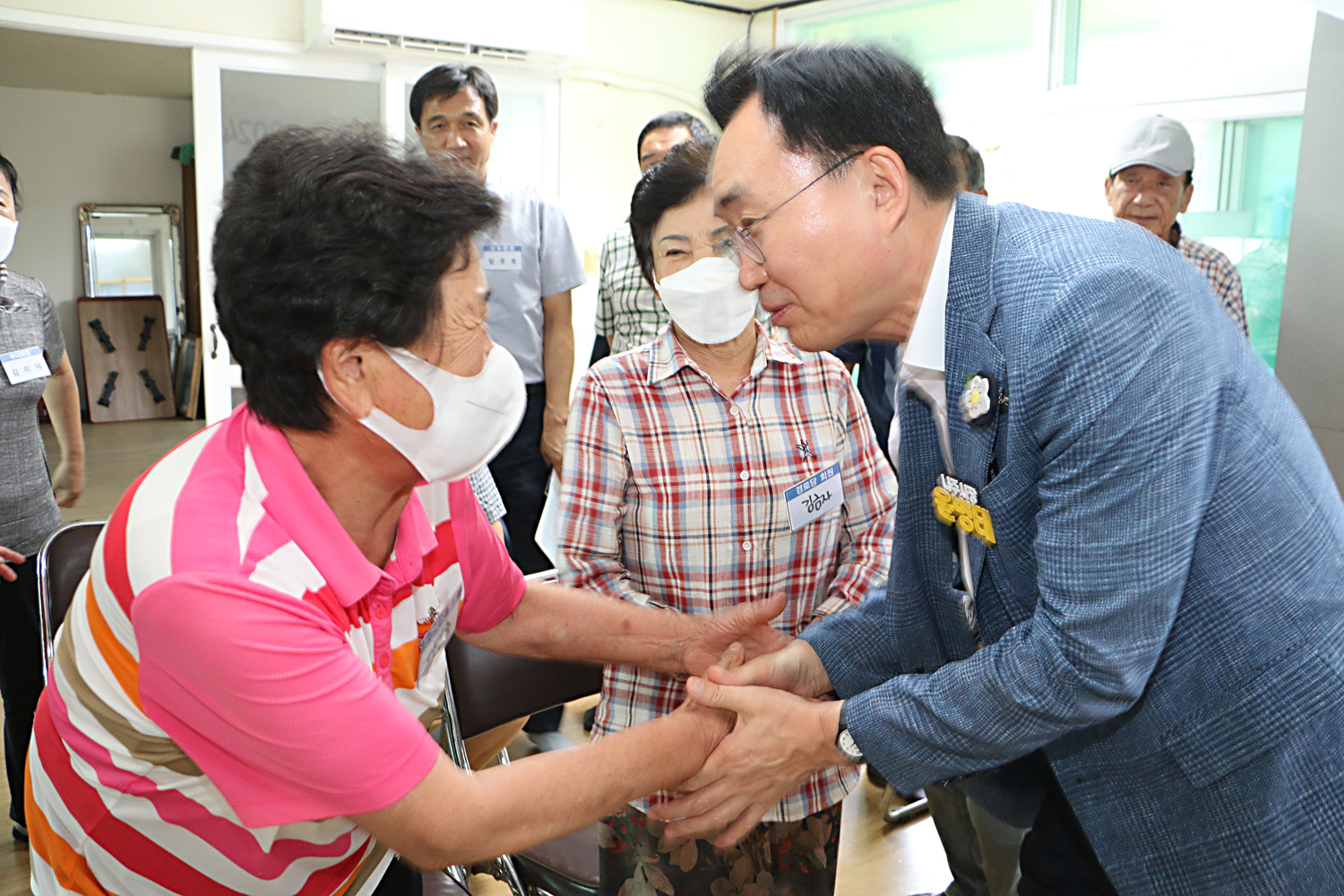 무더위 쉼터 현장 점검 나주시장이 경로당을 방문하여 여성 어르신과 악수를 나누는 모습