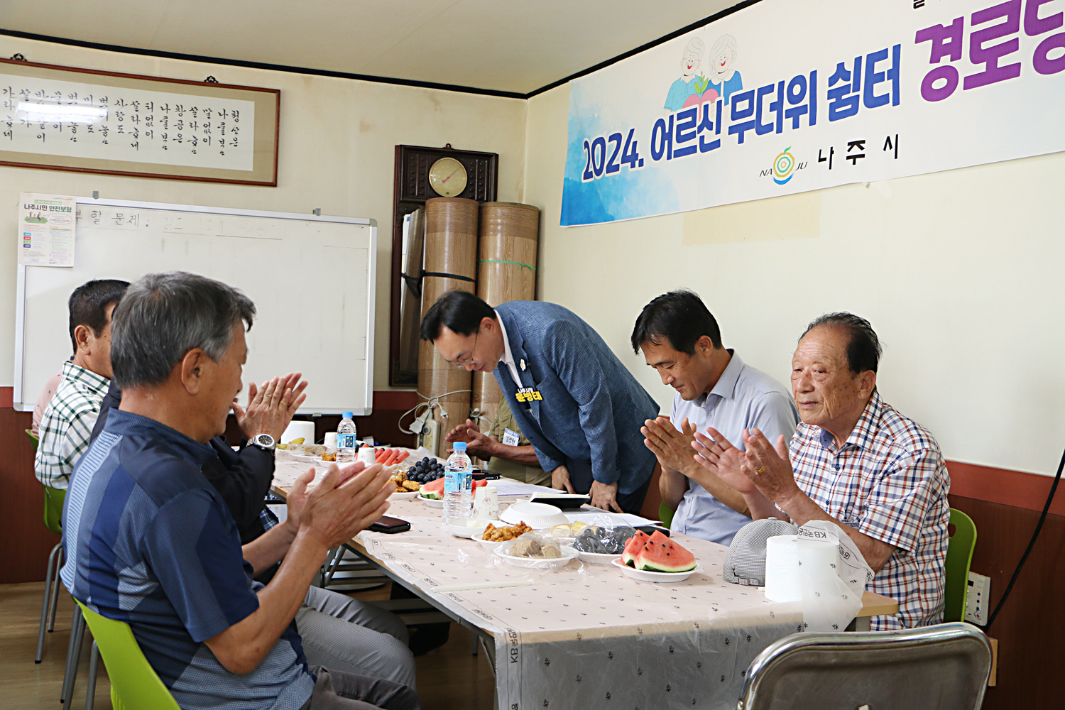 무더위 쉼터 현장 점검 나주시장이 인사말을 끝내고 허리 굽혀 마을 어르신들께 인사를 하고 있는 모습과 박수를 쳐 주고 있는 어르신들의 모습