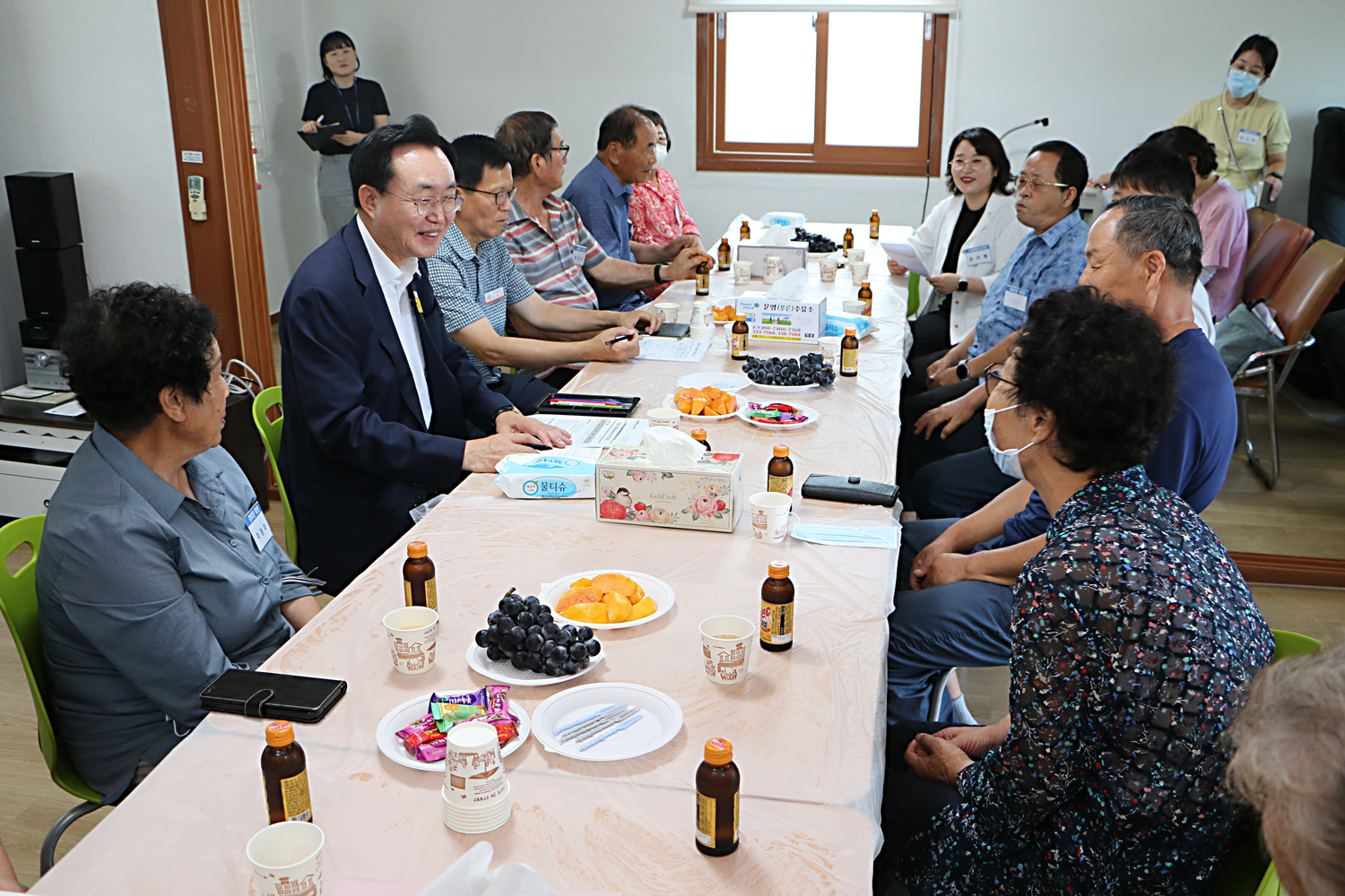 무더위 쉼터 현장 점검 나주시장과 대각선으로 마주앉은 여성 어르신이 건의사항을 말하고 있고 나주시장이 미소를 지으며 듣고 있는 모습