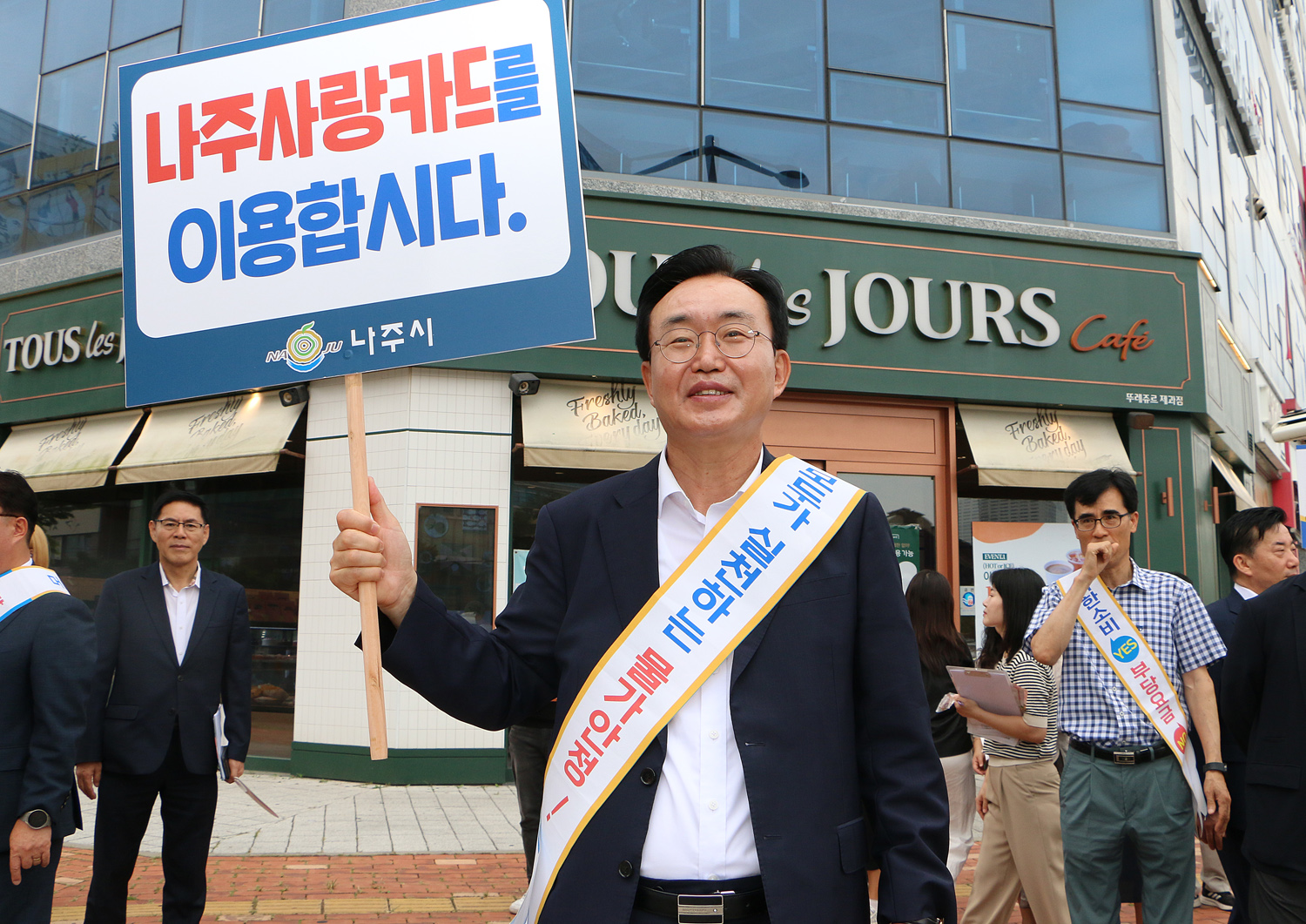 추석맞이 지역상품 판매 촉진 캠페인 및 청렴실천, 고향사랑 기부제 홍보 캠페인 뚜레주르 상점 앞 나주시장이 나주사랑 카드 이용 피켓을 들고 홍보 켐페인을 하고 있는 모습