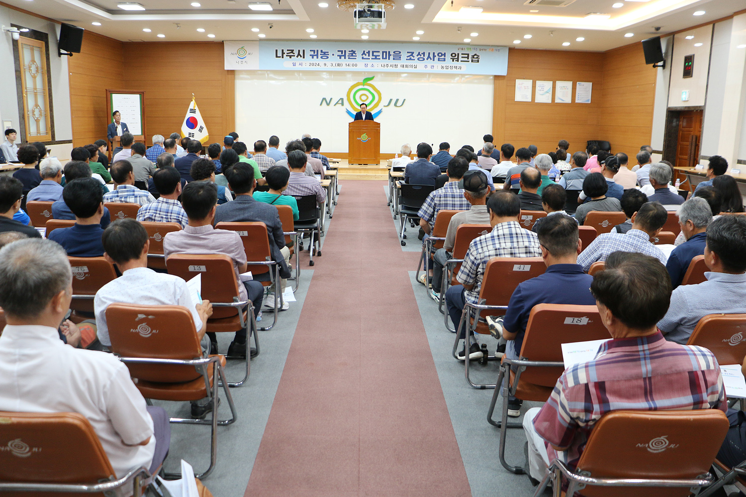 귀농귀촌 선도마을 조성사업 워크숍 나주시장의 인사말 모습가 참석자들의 앉아 있는 뒷모습 전면