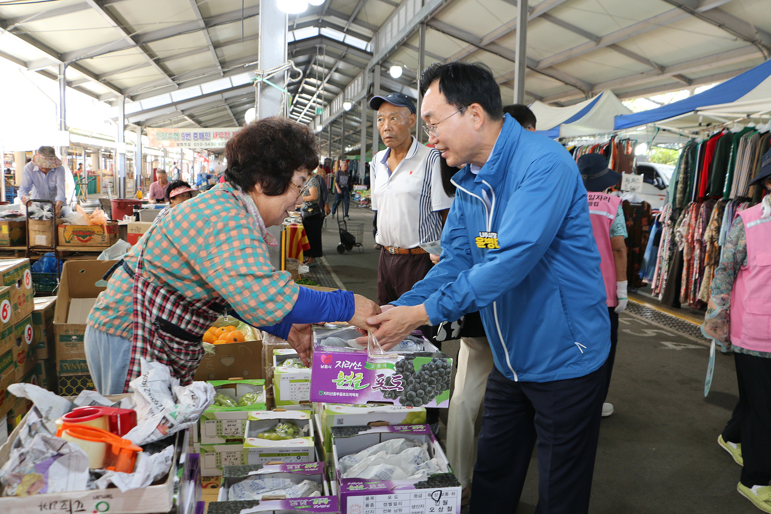 추석 명절맞이 영산포 풍물시장 장보기 행사 과일을 판매하고 있는 여성 상인분에게서 포도 한박스를 구매하고 건네받고 있는 나주시장의 모습