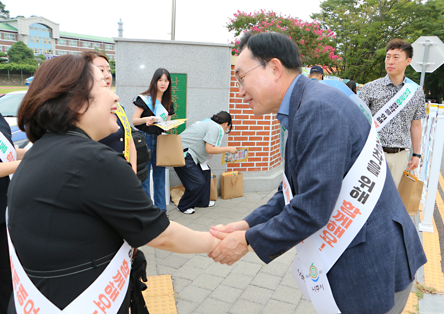 민, 관, 경 합동 어린이 교통안전 캠페인 중앙초교 앞에서 나주시장과 나주중앙초교 교장이 악수를 나누며 인사를 하고 있는 모습