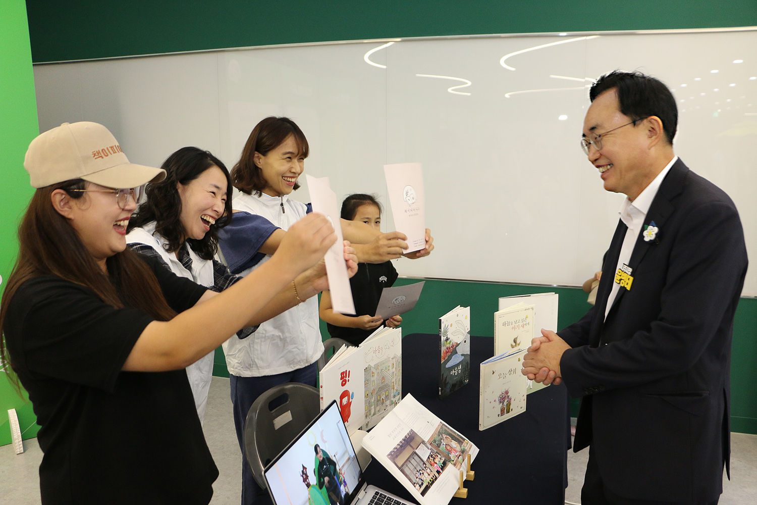 2024년 전라남도 청년의 날 행사 나주시장이 행사장에서 부스를 운영하는 여성 3명의 축하의 맞이를 보며 웃고 있는 모습