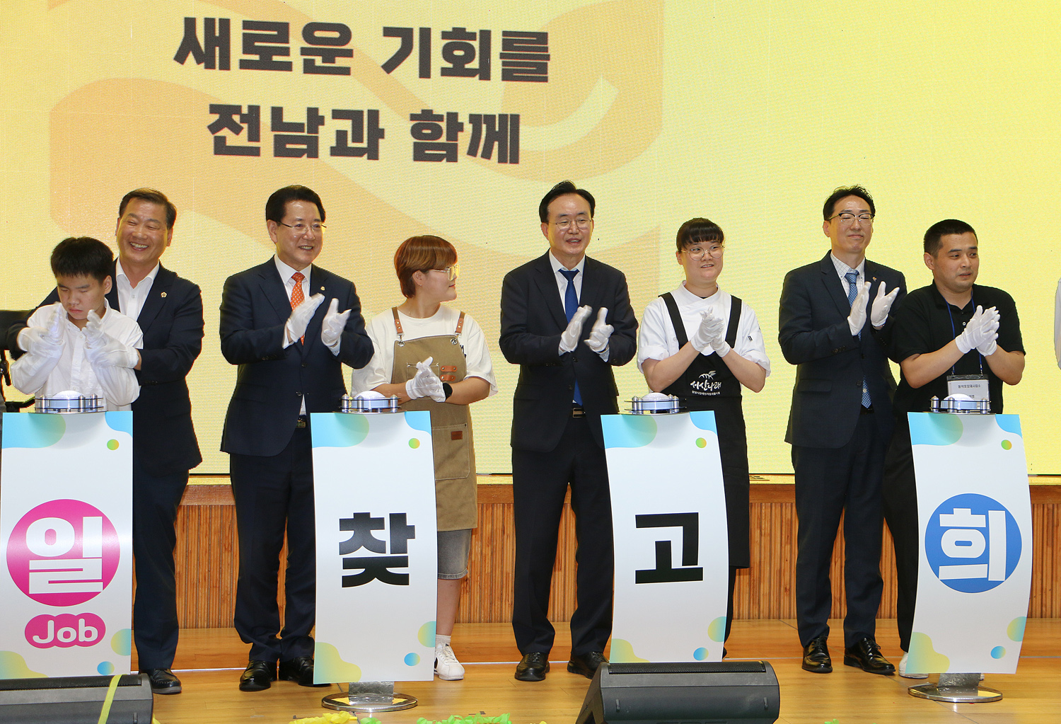 2024 전라남도 장애인 일자리 박람회 전라남도지사, 나주시장, 장애인 소년, 소녀들이 기념 세레모니 축포가 터진 후 단상 위에서 박수를 치고 있는 모습