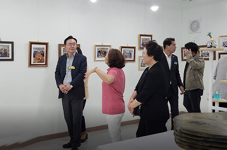 이야기가 있는 마을 축제 나주시장이 전시장에서 여성 관계자의 설명을 듣고 있는 모습