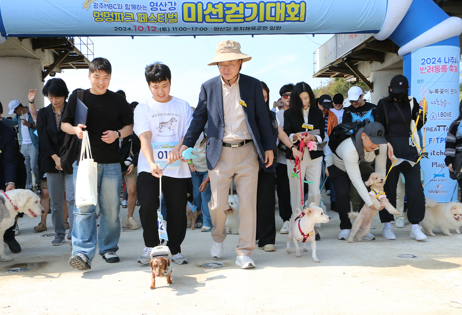 영산강 멍멍파크 페스티벌 나주시장과 행사 관계자가 강아지 목줄을 잡고 걷기대회 출발을 하고 있는 모습