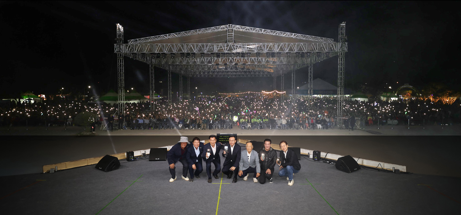 영산강축제 폐막식 나주시장과 국회의원 및 관계자들이 주무대에서 뒤로 돌아서 앉아 핸드폰 불빛을 켜고 참석한 시민들과 함께 기념촬영을 하는 모습