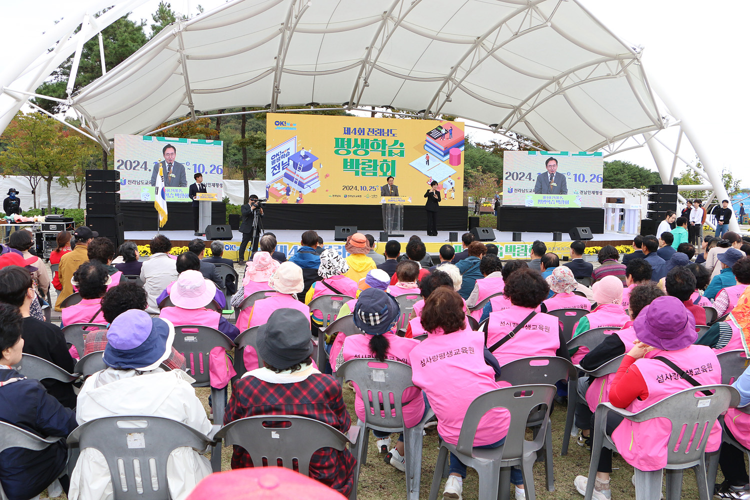 제4회 전라남도 평생학습박람회 개막식 나주시장의 축사 모습과 참석자들이 앉아 있는 뒷모습