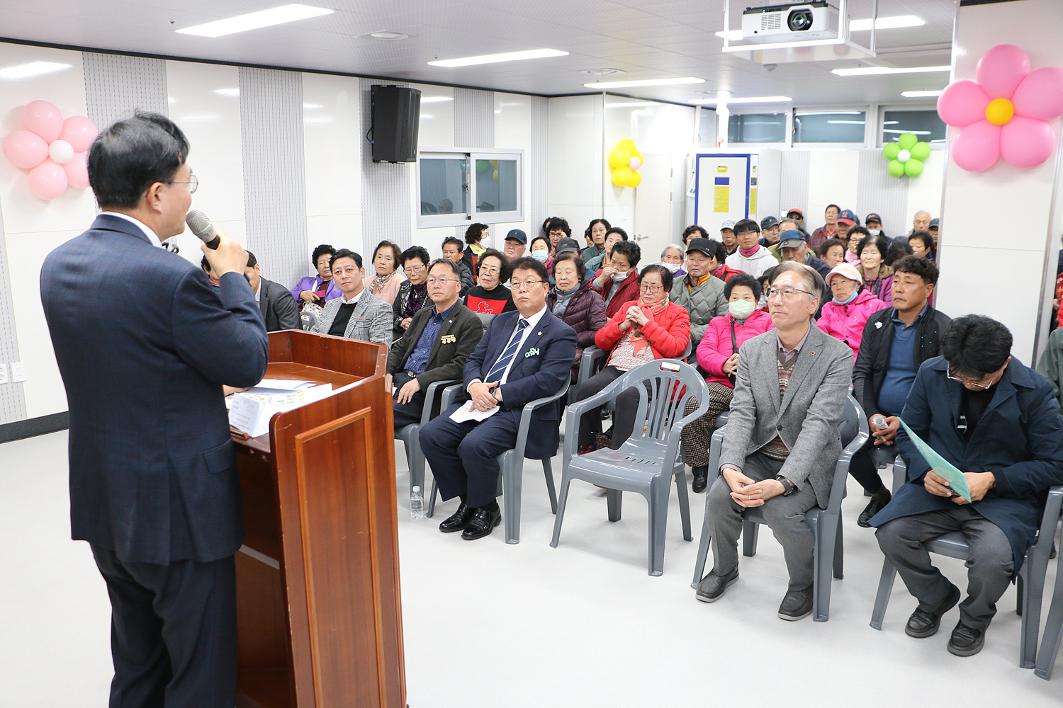 나주시노인복지관 별관 리모델링 준공식 축사를 하고 있는 나주시장의 뒷편에서 촬영한 모습 참석자들의 앉아 있는 앞모습이 함께 보인다