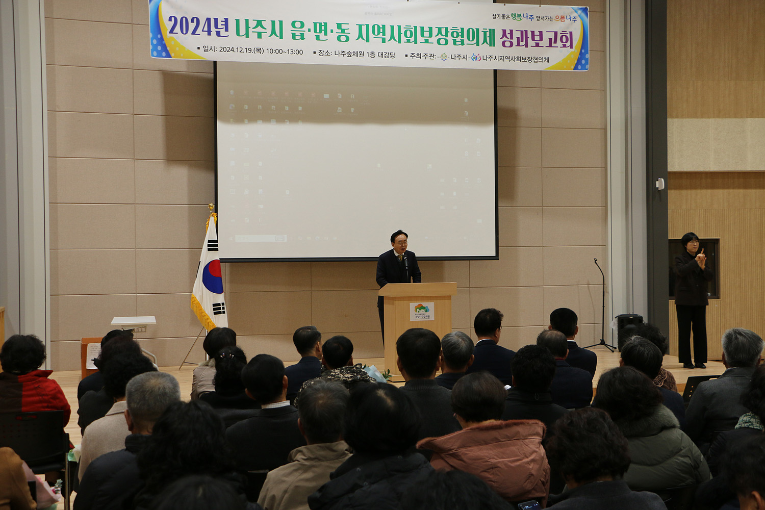 읍면동 지역사회보장협의체 성과보고회 나주시장의 축사모습과 참석자들이 앉아 있는 모습 정면촬영