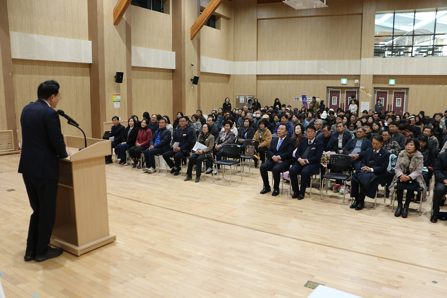 읍면동 지역사회보장협의체 성과보고회 축사를 하고 있는 나주시장의 으측면에서 촬영한 모습 참석자들의 앞모습이 보인다