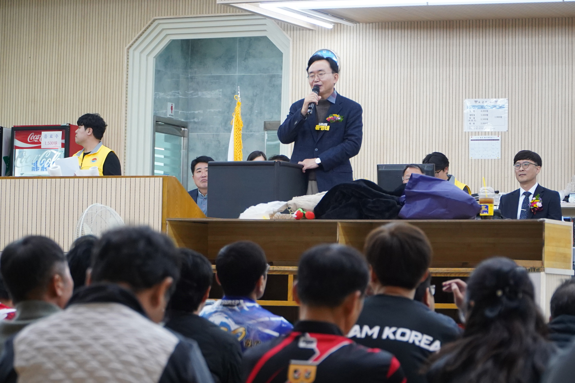 윤병태 나주시장이 무대 위에 올라 연설하고 있고, 많은 관람객들이 바닥에 앉아 연설자를 바라보고 있는 볼링장 내부 전경