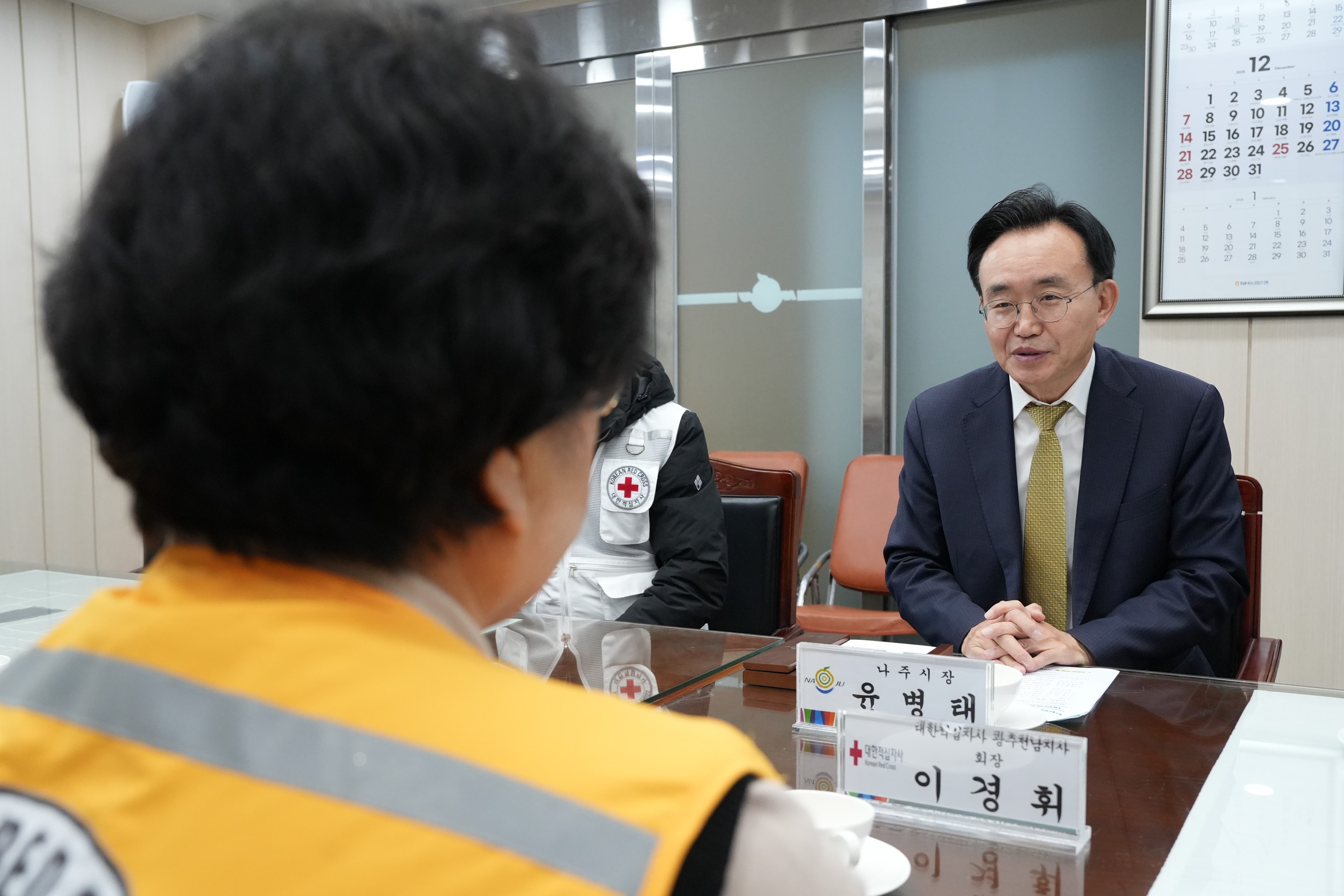 윤병태 나주시장이 회의 테이블 맞은편에 앉은 사람을 바라보며 대화하고 있는 모습