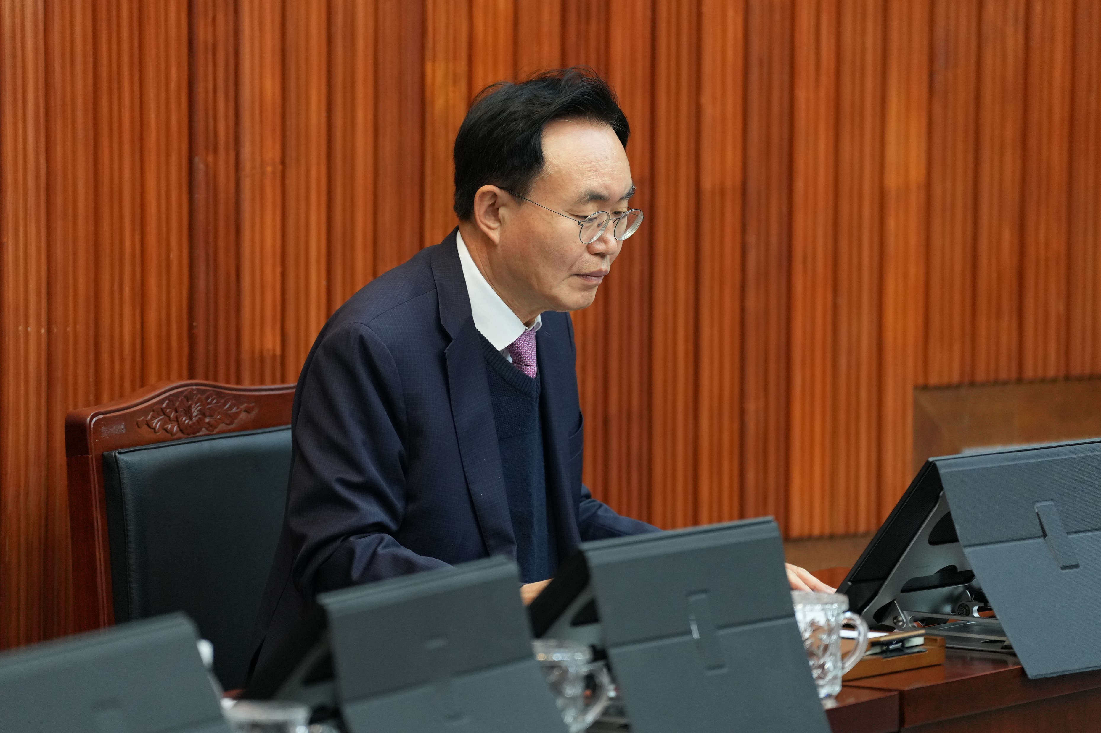 윤병태 나주시장이 회의장에서 앉아 태블릿 화면을 내려다보는 클로즈업 사진