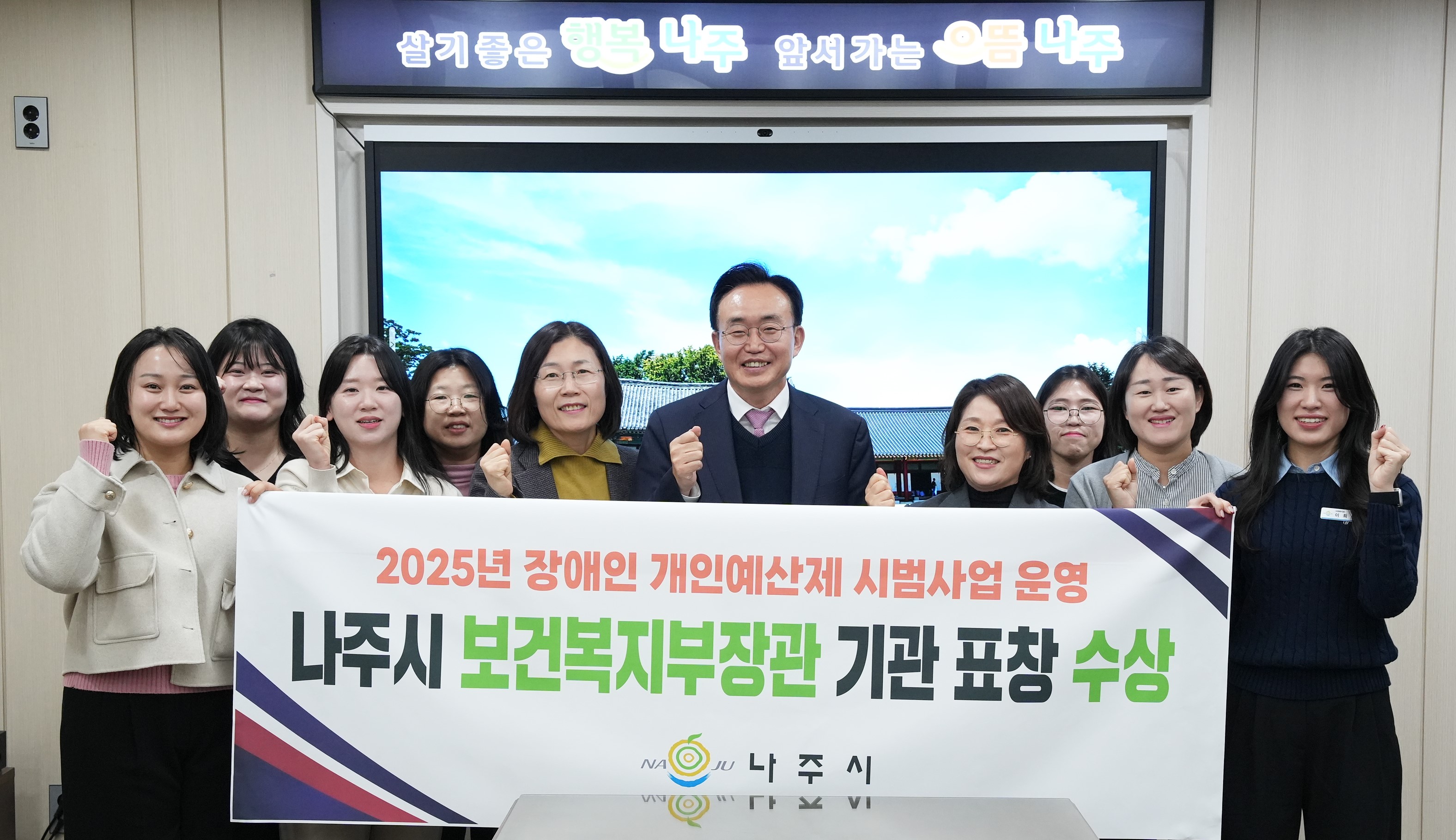  나주시 공무원들(중간 나주시장 윤병태)이 '2025년 장애인 개인예산제 시범사업 운영 나주시 보건복지부장관 기관 표창 수상' 현수막을 들고 단체 사진을 찍는 모습