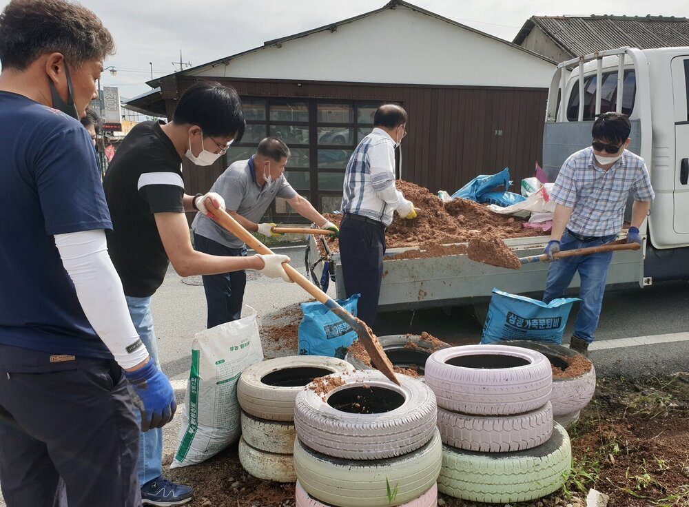 나주 영산동, 청정전남 으뜸마을 만들기 활동으로 꽃심기할 타이어에 삽으로 트럭에 실려있는 흙을 옮겨 담고 있다