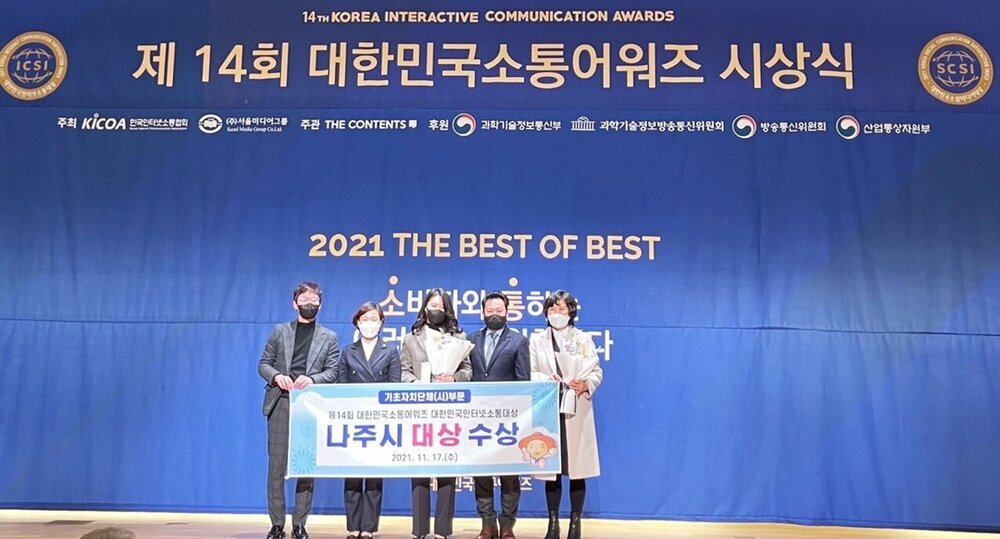 제 14회 대한민국소통어워즈 시상식 2021 THE BEST OF BEST (나주시 대상 수상)라고 적힌 현수막을 들고 수상자들이 기념사진을 찍고 있다