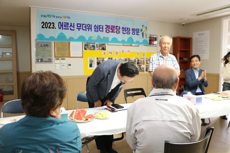 우미린 경로당 무더위 쉼터 방문 나주시장이 경로당 어르신의 소개로 고개 숙여 인사를 하고 있는 모습
