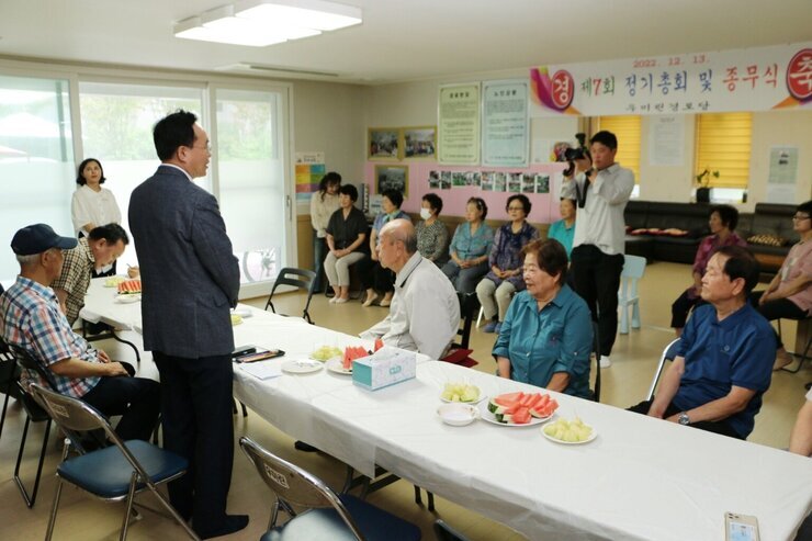 우미린 경로당 무더위 쉼터 방문 나주시장이 인사말을 하고 있는 뒷모습이 보이고 경로당 어르신들의 앉아있는 모습