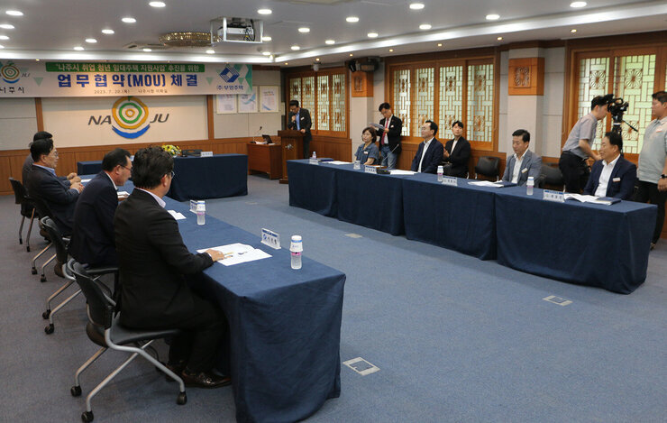 취업청년 임대주택 및 임대보증금 지원 업무 협약식 나주시장과 시청 간부 및 부영주택 대표와 임직원들이 업무협약을 위해 자리에 앉아 있는 모습 전면
