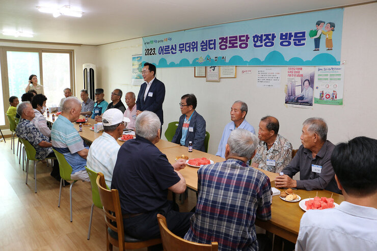 무더위 쉼터 방문 - 공산면 나주시장이 자리에 서서 인사말을 하고 있는 모습과 경로당 어르신들은 앉아 있는 모습