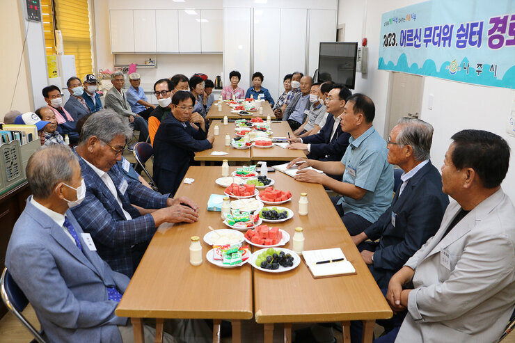 노안면 무더위 쉼터 방문 나주시장과 경로당 어르신들이 자리에 앉아 있는 전체 모습