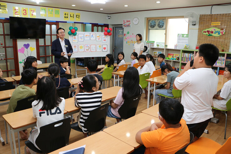 송월지역아동센터 방문 간담회 남자아이가 자리에 서서 질문을 하고 있고 나주시장이 질문을 듣고 있는 모습