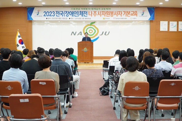 전국장애인체전 자원봉사자 기본교육 나주시장이 인사말을 하고 있고 참석자들의 앉아 있는 뒷모습
