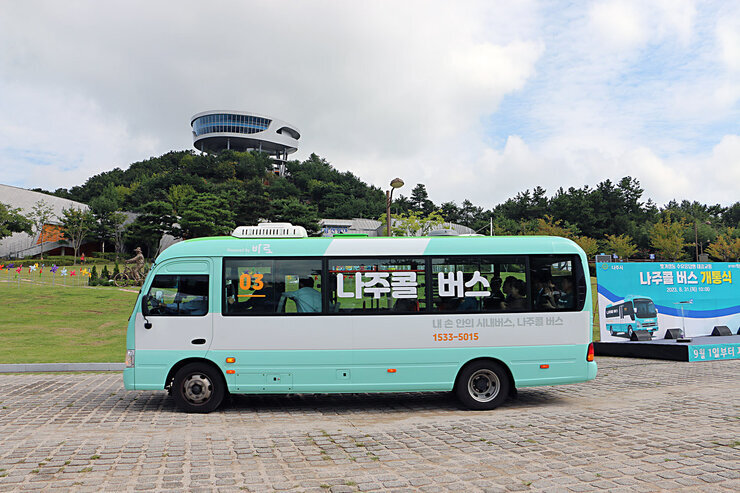 나주콜 버스 개통식 콜버스가 빛가람 전망대를 배경으로 출발하고 있는 모습