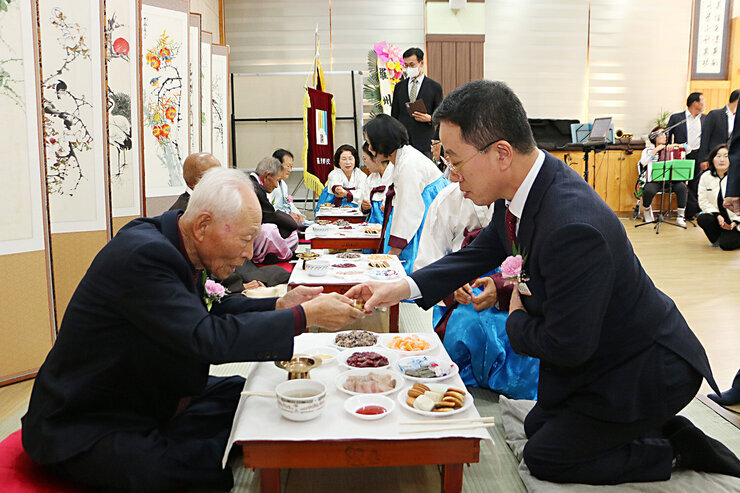 나주향교 기로연 나주시 부시장이 기로연장 앞쪽에서 장수상을 받은 어르신께 술을 올리고 있는 측면 모습