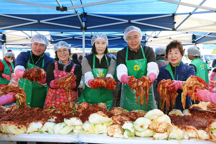 새마을부녀회 김장나누기 행사 나주시장과 배우자, 새마을부녀회 회장 등 2명이 김장한 김치를 들어 올리며 사진촬영에 응하고 있는 모습