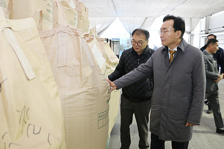 공공비축미곡 수매현장 방문 나주시장과 농협 관계자가 창고에 비축된 톤백 앞에서 대해 이야기를 나누는 모습