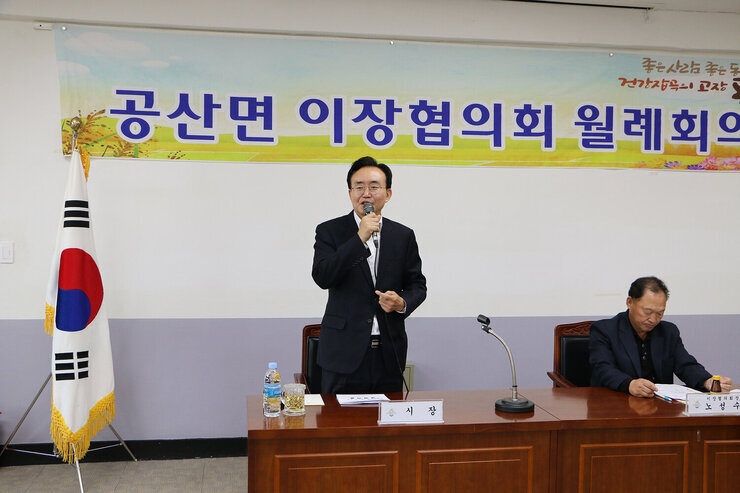 공산면 이장협의회 월례회의 회의장의 나주시장이 자리에 서서 인사말을 하고 있는 모습 