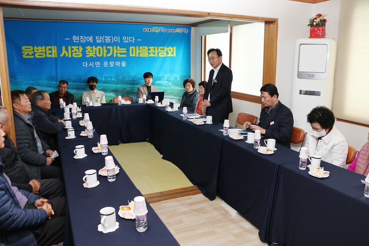 찾아가는 마을좌담회 회관에 어르신들이 앉아 있고 나주시장이 서서 인사말을 하고 있는 모습