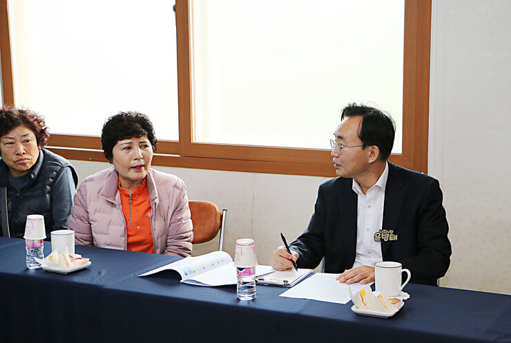 찾아가는 마을좌담회 나주시장이 여성분의 건의사항에 대해 여성분을 바라보며 메모를 하고 있는 모습