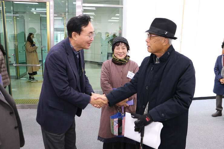 제6회 출향작가전 개전식 나주시장이 작품전에 참석한 남성 어르신과 악수를 하며 대화를 나누는 모습