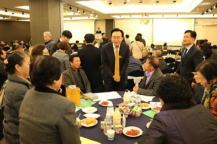제5회 나주로컬푸드 생산자 전진대회 나주시장이 원형테이블에 앉아 있는 참석자들에게 인사를 하고 있는 모습