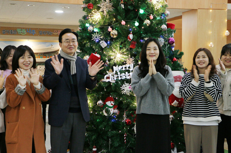 시청 청사 로비 성탄트리 점등식 시장님의 양 옆으로 여직원들이 함께 박수와 손을 흔들며 점등식 축하를 하는 모습
