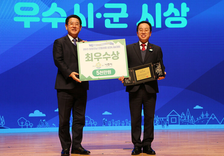 청정전남 으뜸마을 성과나눔대회 나주 부시장과 전라남도지사가 최우수상 판넬을 들고 기념촬영을 하고 있는 모습 