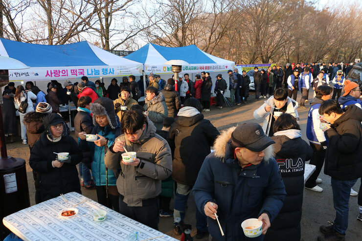 금성산 해맞이 행사  두꺼비봉에 마련된 떡국 나눔행사에 많은 시민들이 떡국을 먹고 있는 모습과 줄을 서고 있는 모습 전체