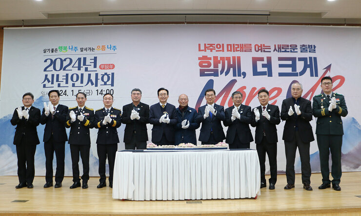 2024년 신년인사회 나주시장과 주요 내빈들이 떡케잌 절단을 하고 뒤에 서서 박수를 치고 있는 모습