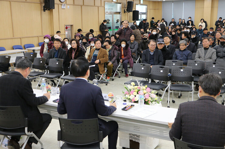 봉황면 주민과의 대화 남성 면민 한분이 자리에 일어나서 마이크를 잡고 건의사항을 말을 하고 있고 나주시장이 듣고 있는 뒷모습