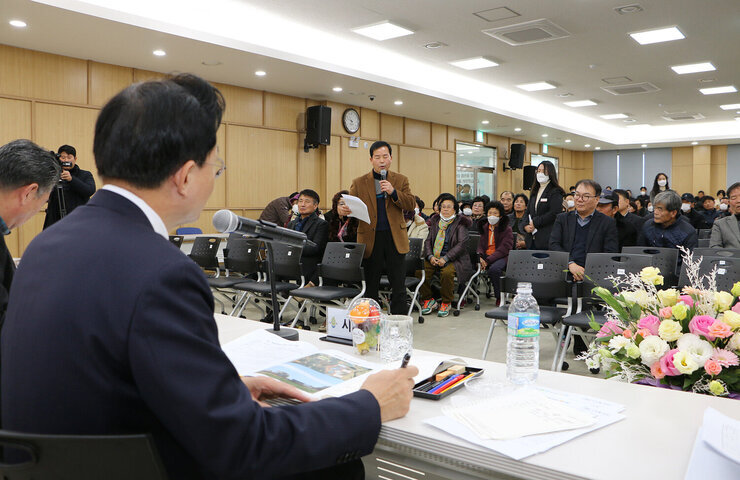 봉황면 주민과의 대화 앞줄의 주민 한분이 자료를 들고 건의사항을 말하고 있고 듣고 있는 나주시장의 옆모습 측면에서 촬영