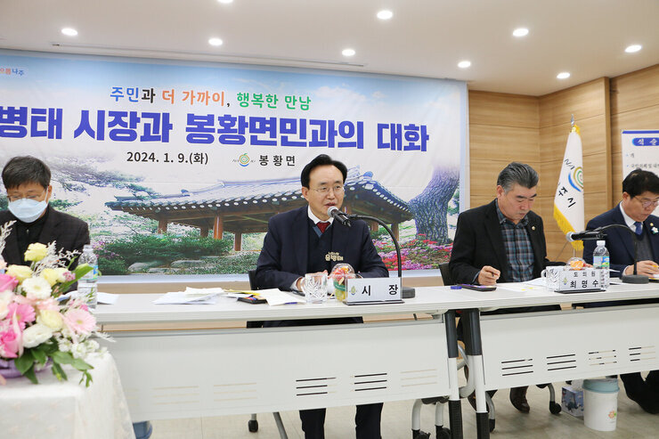 봉황면 주민과의 대화 대화석에 앉아 있는 간부공무원과 도의원, 시의원 가운데에서 나주시장이 주민의 질문에 답변을 하고 있는 모습