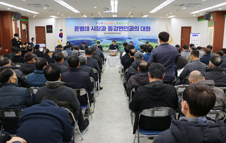 동강면 주민과의 대화 대화장에서 남성 주민이 질의를 하고 있고 대화석에서 질의를 듣고 필기를 하고 있는 나주시장과 간부공무원, 도의원, 시의원 모습 전면