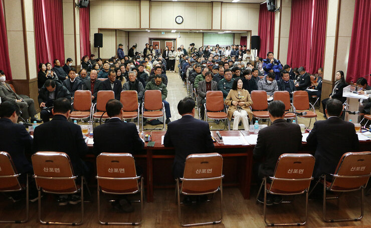 산포면 주민과의 대화 대화석 뒷편에서 퐐영한 나주시장과 간부공무원, 시의원의 뒷모습과 참서자들의 앞모습 , 우픅에 남성 주민 한분이 마이크를 잡고 질문을 하고 있는 모습